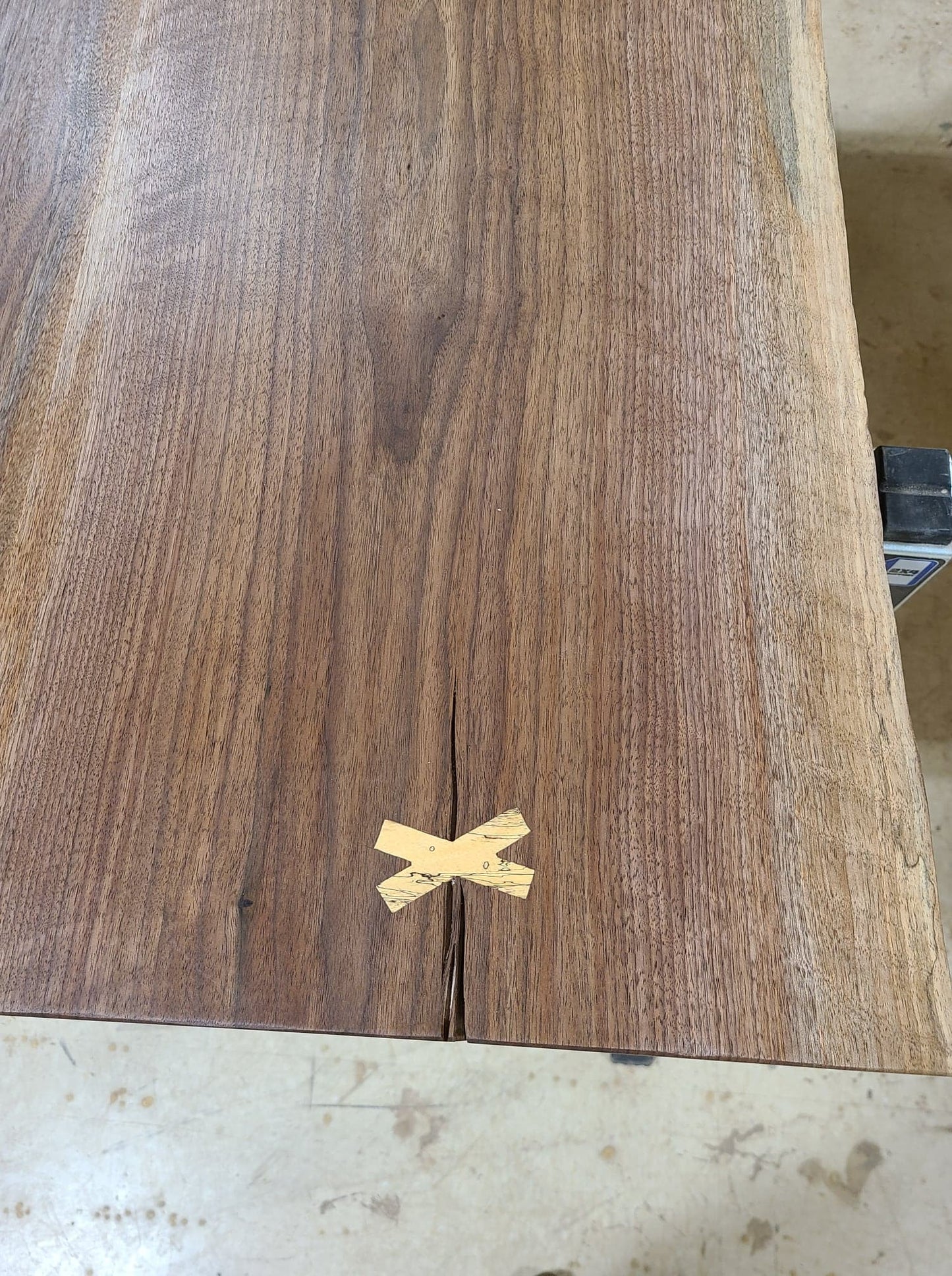 Closeup of table top showing lighter colored x-shaped inlay.
