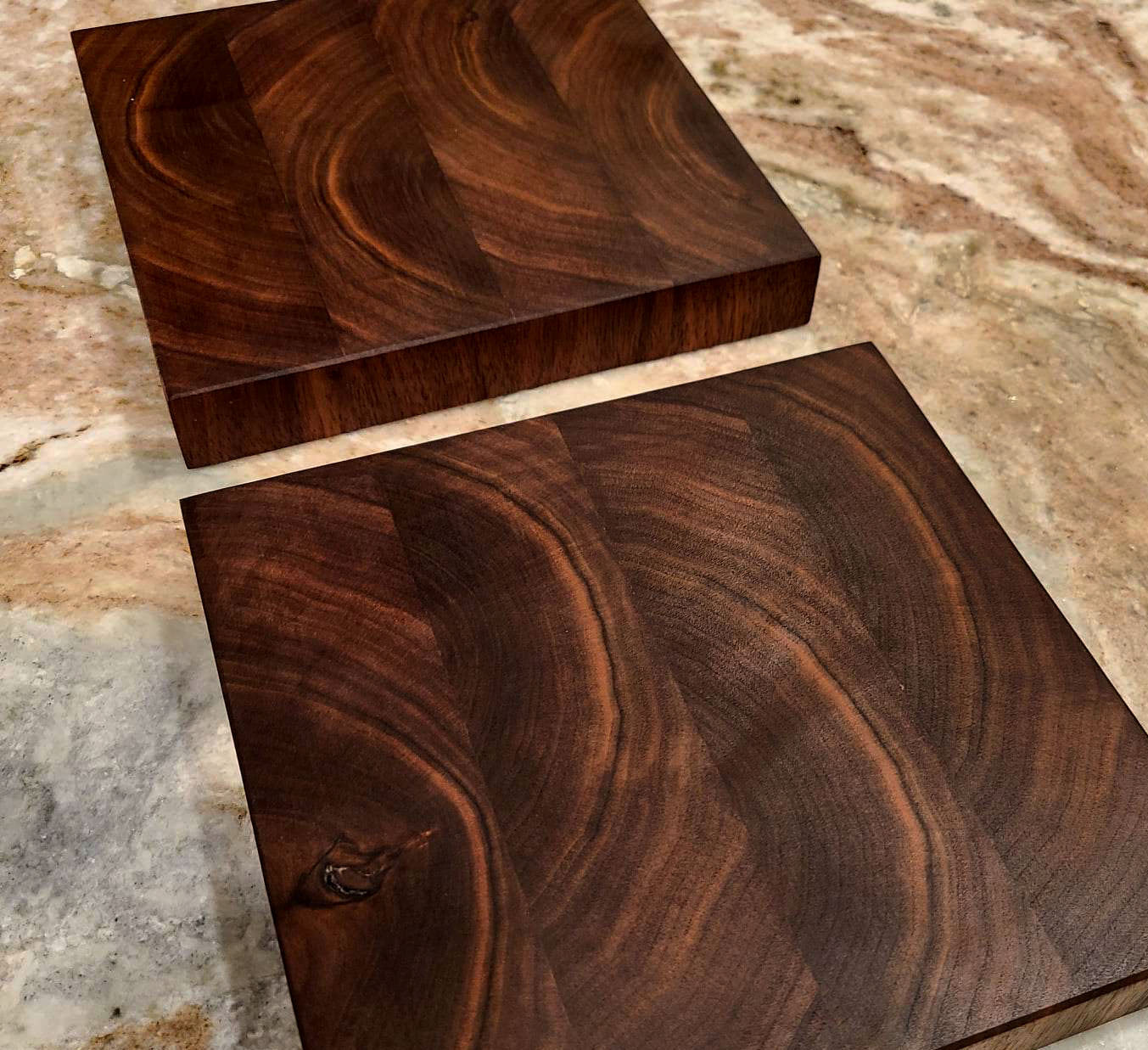 2 Rising Sun cutting boards sitting on a marble surface next to each other, highlighting the thickness of the boards and the wood grain.