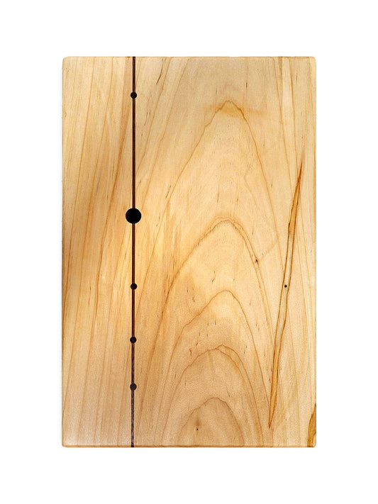 Top view of cutting board made from light wood, with the wood grain displayed beautifully. On the left, it is inlaid with a strip of dark walnut with 4 small circles and one large circle to appear kind of like a constellation.