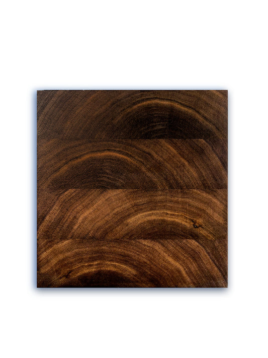 Top view of cutting board. The board features 4 strips of walnut cut to show the end grain. The end grain, which appears like a sun coming over the horizon, alternates from a right offset to a left offset from strip to strip. 